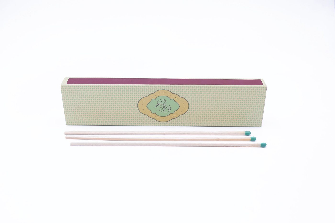 Extra long safety matches beside a printed mint green slide matchbox